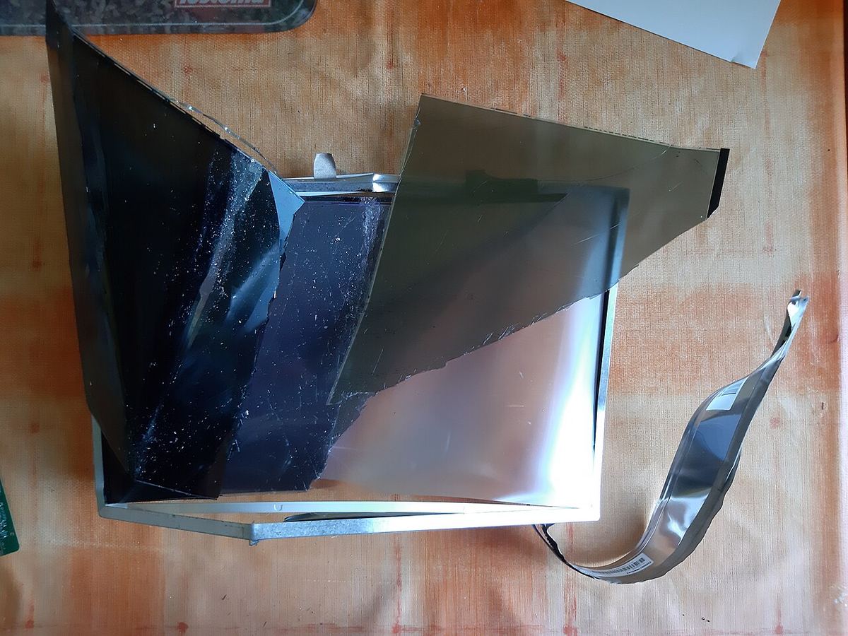 A dead LCD panel taken apart. The thin glass and film layers are why a panel cracks if it bends while you pry it out.