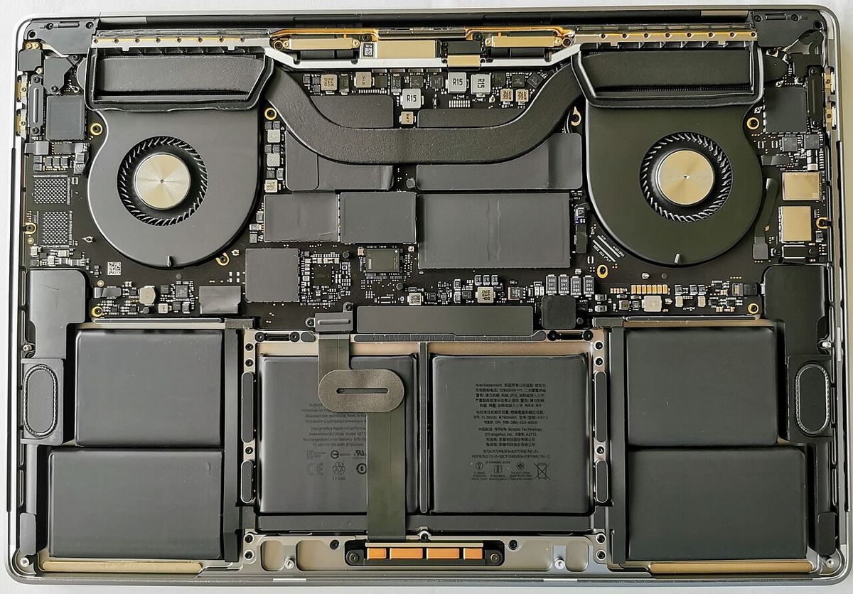 A MacBook Pro 16 inch with the bottom case off. The battery fills most of the base, so you disconnect it before touching anything else.